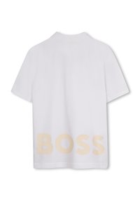 Polo shirt bianco a maniche corte con una texture morbida e un grande logo beige "BOSS" stampato sulla schiena. Design del colletto classico.