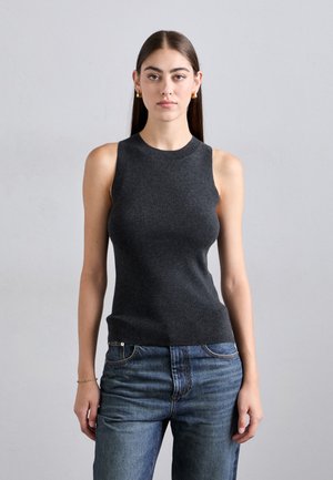 Haut sans manches gris foncé avec un col haut et une coupe ajustée, associé à un jean en denim bleu. Texture lisse avec une finition côtelée.