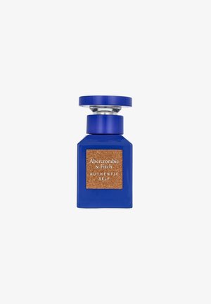 Flacon de parfum en verre bleu avec un accent en liège et un capuchon argenté, présentant une étiquette avec l'inscription "Abercrombie & Fitch AUTHENTIC SELF."