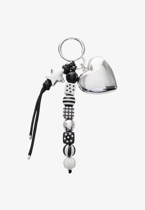 Porte-clés avec un cœur en argent poli, des perles noires et blanches, comprenant des motifs de rayures et de pois, sur un cordon noir.