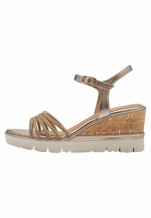 Metallisch goldene Keilsandale mit korktexturiertem Absatz, mehreren Riemen vorne, Knöchelriemen mit Schnalle und einer klobigen weißen Sohle.