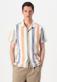 Camisa de botão de manga curta com riscas verticais multicoloridas em laranja, bege, azul e verde. Apresenta um bolso no peito.