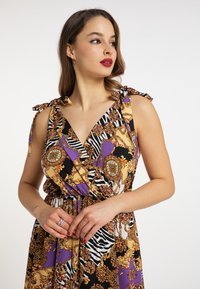 Abito multicolore caratterizzato da una combinazione di motivi floreali e a zebre, con dettagli in viola, nero e oro. Si lega alle spalle con una vita stretta.