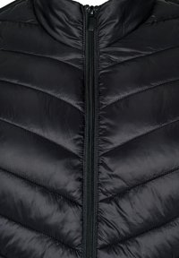 Juodas paminkštintas liemenė su aukštu apykakle, turintis užtrauktuką ir chevrono raštu quilted tekstūrą. Pagamintas iš lygaus, lengvo medžiagos.