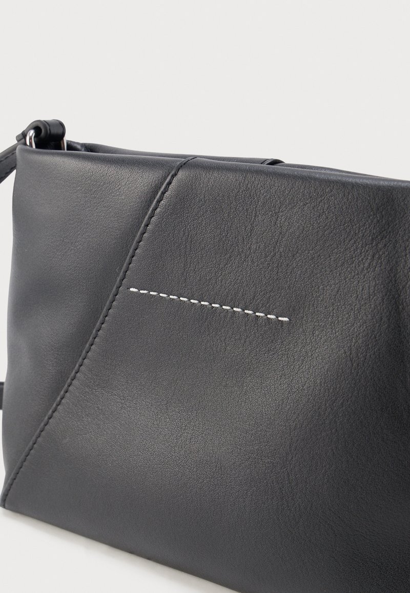 Black leather crossbody bag with diagonal seam and single row of white stitching on front panel.