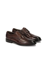 Scarpe eleganti in pelle marrone con finitura liscia, design con lacci, punta affusolata e dettagli di cucitura discreti lungo i lati.