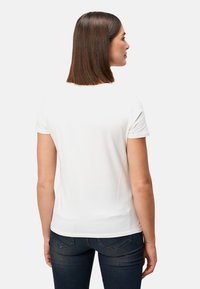 Weißes T-Shirt mit kurzen Ärmeln und rundem Ausschnitt, aus weichem Stoff. Die Rückansicht zeigt ein tailliertes Design und schlichte Nähdetails.