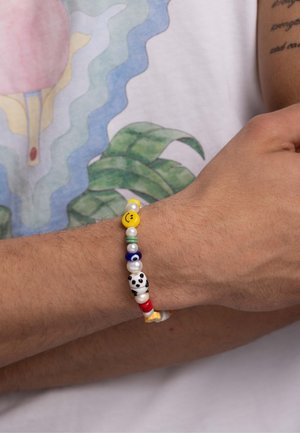 Colorful beaded bracelet featuring smiley face, panda, and eye designs. Multi-colored round beads with shiny and matte finishes on elastic band.