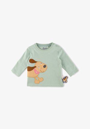 Chemise bébé à manches longues vert clair avec une application représentant un chien de dessin animé souriant et un petit jouet en forme de chien attaché en bas à droite.