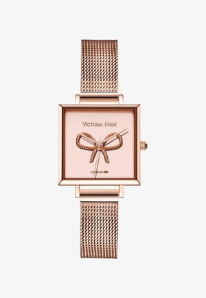 Montre bracelet carrée en or rose avec bracelet en maille, comportant un motif nœud sur le cadran et la marque "Victoria Hyde London".