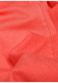 Roter Stoff mit einer leicht strukturierten Oberfläche. Das Material wirkt weich und ist gefaltet, wobei eine saubere Naht entlang der Kante sichtbar ist.