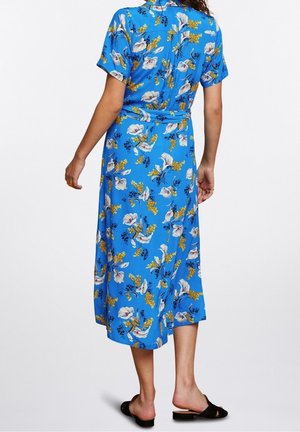Robe bleue à fleurs avec manches courtes, taille cintrée et ourlet mi-long. Présente des motifs floraux blancs et jaunes sur fond bleu.