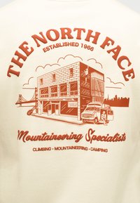Εικονογράφηση του καταστήματος The North Face με έναν ορειβάτη που σκαρφαλώνει στο κτίριο, ένα βαν σταθμευμένο έξω και τον ορίζοντα της πόλης στο παρασκήνιο.