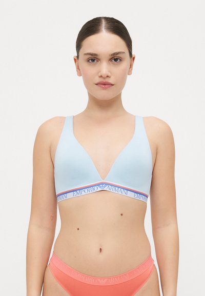 Helle blaue, dreieckige Bralette mit breitem elastischem Bund, der das Logo "Emporio Armani" in Blau und Orange zeigt. Glattes Material, minimale Nähte.
