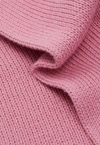 Strikket stoff i myk rosa, med et teksturert ribbestrikkmønster. Materialet ser glatt ut med en lett glans, og viser milde folder.