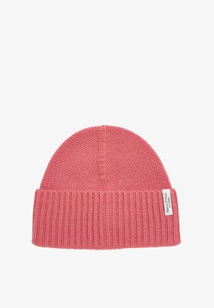 Bonnet tricoté en rose pâle, avec un ourlet côtelé et un dessus lisse. Étiquette cousue sur l'ourlet, indiquant le nom de la marque.