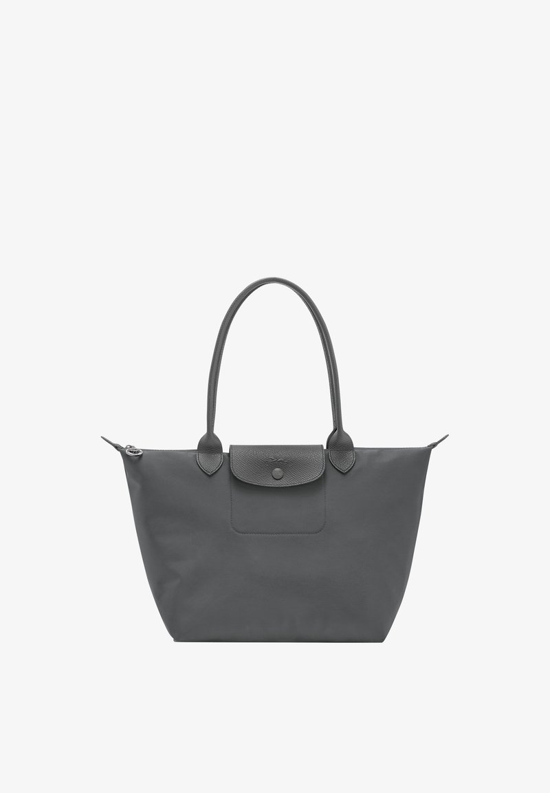 Black tote bag with long handles, top zipper, and front flap pocket with button closure on a white background.