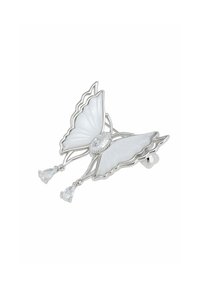 Silver butterfly brooch with white enamel wings, featuring a central clear stone and dangling pear-shaped accents. Delicate, detailed design.