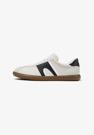 Vit sneaker med svart och vitt accent och en brun sula, visad från sidan för att framhäva dess design och form.