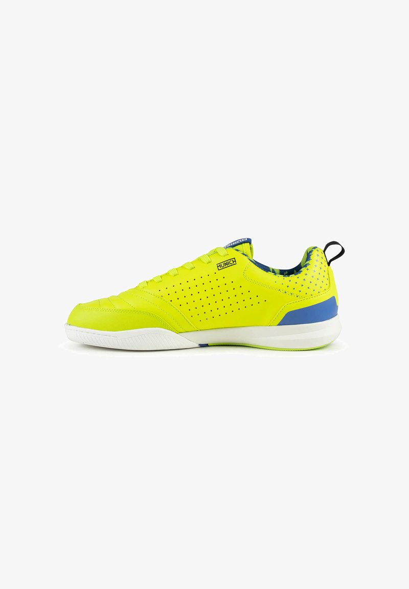 Chaussure de sport jaune vif avec des accents bleus, côtés perforés, semelle blanche et languette à tirer au talon, vue de l’extérieur.