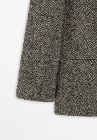 Giacca di lana a motivo houndstooth con una miscela testurizzata di grigio e marrone, con taglio dritto e tasche laterali.