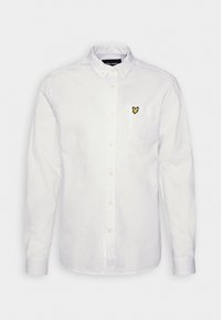 Camisa blanca de botón en tejido de algodón, con un pequeño logo de mariposa amarilla bordado en el bolsillo del pecho, mangas largas con puños de botón.