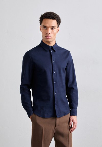 Navy blue long-sleeve shirt made of smooth fabric, featuring a classic collar, button-down front, and cuffed sleeves.