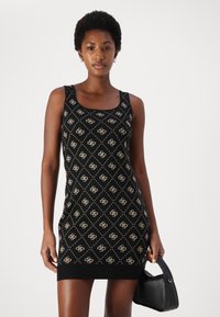 Black knitted dress with a diamond pattern in beige, featuring a scoop neckline and fitted silhouette. Includes ribbed hem at the bottom.