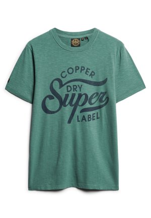 Zielona bawełniana koszulka z krótkim rękawem, okrągłym dekoltem i ciemnoniebieskim nadrukiem "Copper Dry Super Label" na przodzie.