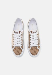 Bruna canvas sneakers med ett monogrammönster, vita snören och gummisulor med en ren, minimalistisk design.