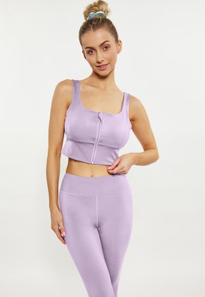 Lilla sports crop top med brede stropper og lynlås foran; parret med matchende højtaljede leggings, begge lavet af glat, strækbart stof.