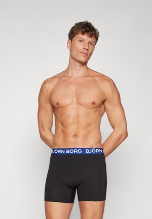 Schwarze Boxershorts aus Baumwolle mit einem blau-weißen "BJÖRN BORG" Logo-Bund, enganliegendem Schnitt und mittellanger Beinlänge.