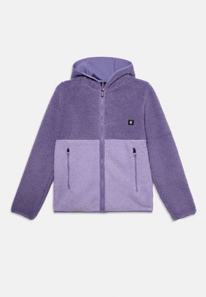 Veste en polaire violette douce et pelucheuse avec capuche et fermeture éclair à l'avant, dotée de deux poches zippées et d'un petit patch logo sur la poitrine.