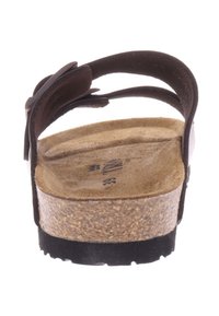 Bruine sandaal met een kurkzool, voorzien van een getextureerde inlegzool en verstelbare banden. De achterkant toont twee gebogen banden voor een veilige pasvorm.