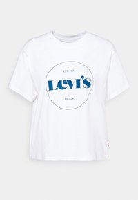 Bílé bavlněné tričko s kulatým výstřihem, na přední straně modrý oválný logo s nápisem "Levi's" a "EST. 1873" umístěné uprostřed, krátké rukávy.