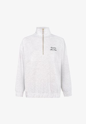 Vaaleanharmaa neulepusero, jossa on korkea kaulus, puolipitkä vetoketju ja kirjailtu "Captain's Sports Club" -logo edessä.