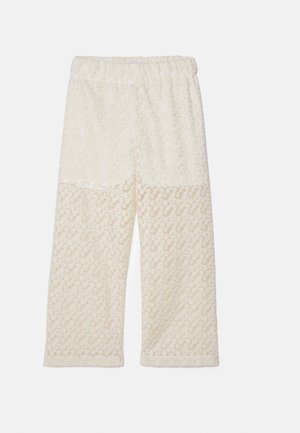 Hlače boje kreme s elastičnom trakom u struku, s teksturiranim cvjetnim uzorkom. Tkanina djeluje mekano s opuštenim, širokim krojem.