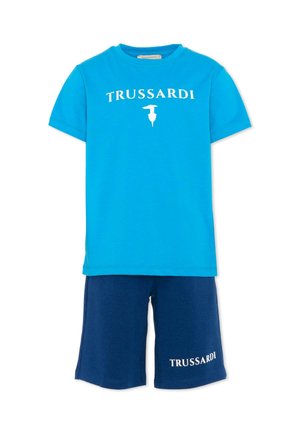 Camicia a maniche corte blu brillante con "TRUSSARDI" e logo, abbinata a pantaloncini blu navy con la scritta "TRUSSARDI" sulla gamba sinistra.