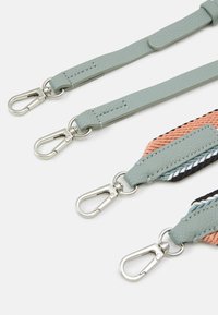 Quatre sangles de sac réglables avec des fermoirs métalliques argentés, deux sangles en cuir bleu clair et deux sangles tissées multicolores.