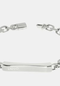 Bracciale in argento con un segmento centrale a barra lucida. Presenta una chiusura sicura e una finitura metallica liscia. Logo incassato sulla barra.