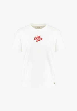 Valge puuvillane T-särk, ümmarguse kaelusega, lühikeste varrukatega, mille ees on punane graafika "Nagu kohalikud teevad". Väike logo aktsent alläärs.