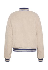 Cremfarbener, flauschiger Sherpa-Jacke mit einem gerippten, marineblauen und weißen gestreiften Kragen und Bündchen; tailliertes Design mit einer weichen Textur.