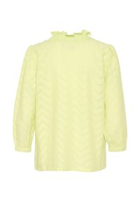 Blusa gialla chiara con un motivo zigzag testurizzato, scollatura arricciata e maniche a sbuffo. Presenta una vestibilità morbida e un tessuto soffice.