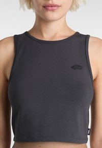 Mörkgrå croppad tanktop, tillverkad av mjukt, elastiskt material med en rundad halsringning, med en liten svart Vans-logga på bröstet.