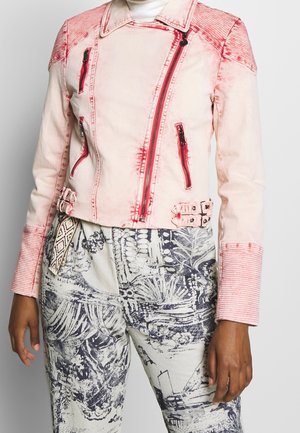 Chaqueta biker rosa claro con detalles de cremallera roja y puños acanalados, combinada con pantalones de cintura alta con patrones abstractos en blanco y negro.