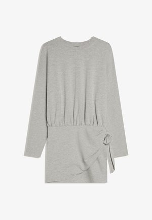 Lichtgrijze jurk met lange mouwen, geplooide taille en zijstrikknoop, gemaakt van zacht gebreide stof.