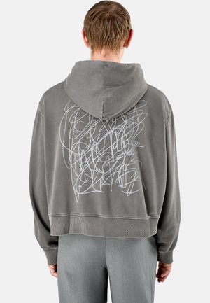 Grijze cropped hoodie met een witte abstracte print op de achterkant. Zachte stof, capuchon met koord, ribgebreide manchetten en zoom.