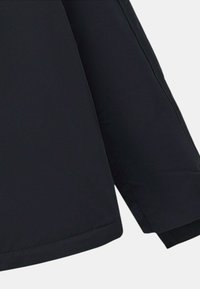 Doudoune noire avec une finition lisse et mate. Présente un ourlet droit et des manches angulaires, mettant en avant un design minimaliste.