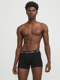 Crne bokserice s brendiranim elastičnim pojasom na kojem piše "JACK & JONES" bijelim slovima. Glatka tkanina koja pristaje uz tijelo bez vidljivih uzoraka.