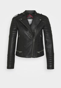 Giacca in pelle nera con chiusura a zip, mostrine sulle spalle, dettagli a coste sulle maniche e due tasche anteriori con zip. L'interno è foderato di rosso.